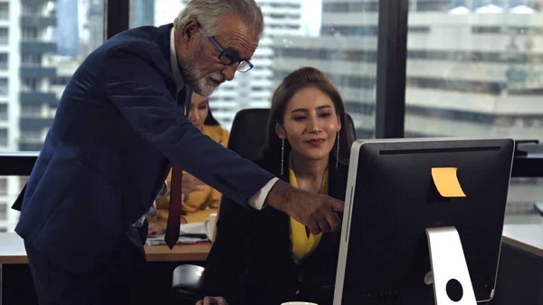 Senior manager gives advice to young woman worker in modern office. Leadership and training concept.;Senior manager gives advice to young woman worker in modern office. Leadership and training concept.