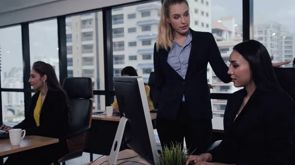 Young leader gives advice to young woman worker in modern office. Leadership and training concept.;Young leader gives advice to young woman worker in modern office. Leadership and training concept.