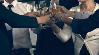 Başarılı iş adamları balo salonunda takım arkadaşlarıyla şarap ve şampanya içerek yeni ürünleri piyasaya sürme projesini kutluyorlar. Kurumsal iş ve insan ilişkileri kavramı. ; Başarılı iş adamları şarap ve şampanya içerler