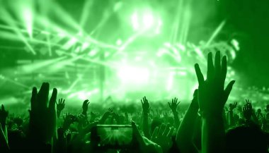 Happy people dance in nightclub DJ party concert and listen to electronic dancing music from DJ on the stage. Silhouette cheerful crowd celebrate New Year party 2020. People lifestyle DJ nightlife.;Happy people dance in nightclub DJ party concert and