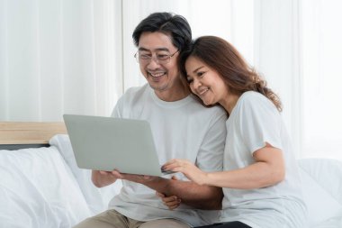 Mutlu Asyalı son sınıf çifti evde iyi vakit geçiriyor. Yaşlıların emekliliği ve sağlıklı vatandaşların ihtiyarlık kavramı.