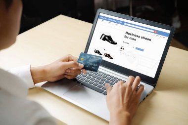 Genç adam, laptop bilgisayar başvurusu ya da web sitesinde online alışveriş yapmak için kredi kartı kullanıyor. E-ticaret ve online alışveriş kavramı.