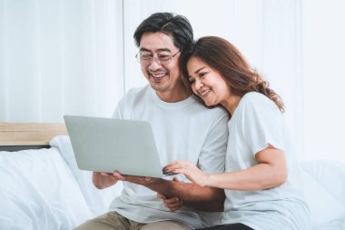 Mutlu Asyalı son sınıf çifti evde iyi vakit geçiriyor. Yaşlıların emekliliği ve sağlıklı vatandaşların ihtiyarlık kavramı.