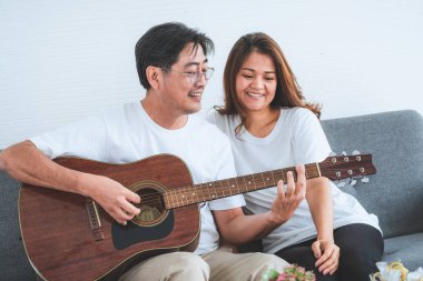 Mutlu Asyalı son sınıf çifti evde iyi vakit geçiriyor. Yaşlıların emekliliği ve sağlıklı vatandaşların ihtiyarlık kavramı.