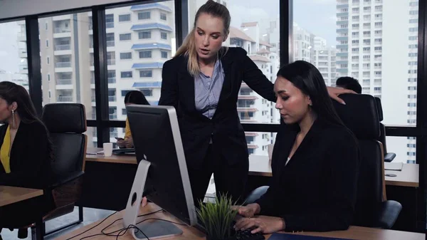 Young leader gives advice to young woman worker in modern office. Leadership and training concept.;Young leader gives advice to young woman worker in modern office. Leadership and training concept.
