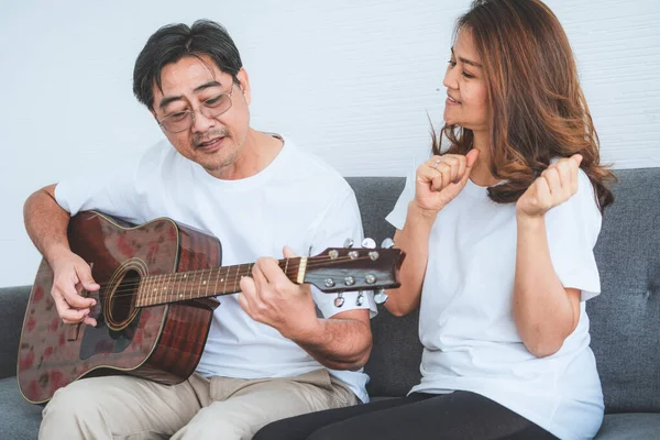 Happy Asian senior couple having good time at home. Old people retirement and healthy citizens elderly concept.