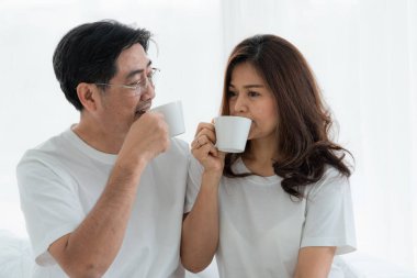 Mutlu Asyalı son sınıf çifti evde iyi vakit geçiriyor. Yaşlıların emekliliği ve sağlıklı vatandaşların ihtiyarlık kavramı.