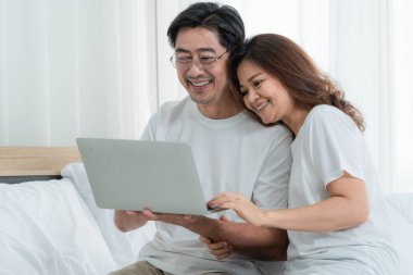 Mutlu Asyalı son sınıf çifti evde iyi vakit geçiriyor. Yaşlıların emekliliği ve sağlıklı vatandaşların ihtiyarlık kavramı.