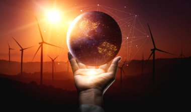 Alternatif enerji ile sürdürülebilirlik gelişimi kavramı. Çevre dostu rüzgar türbini çiftliği ve arka planda yeşil yenilenebilir enerji ile insan eliyle dünya ile ilgilenin..