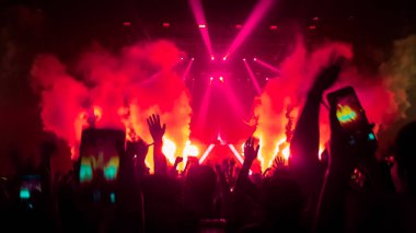 Mutlu insanlar gece kulübü DJ parti konserinde dans eder ve sahnede DJ 'den elektronik dans müziği dinlerler. Siluet dolu neşeli kalabalık 2020 yılbaşı partisini kutluyor. İnsanların yaşam tarzı DJ gece hayatı.
