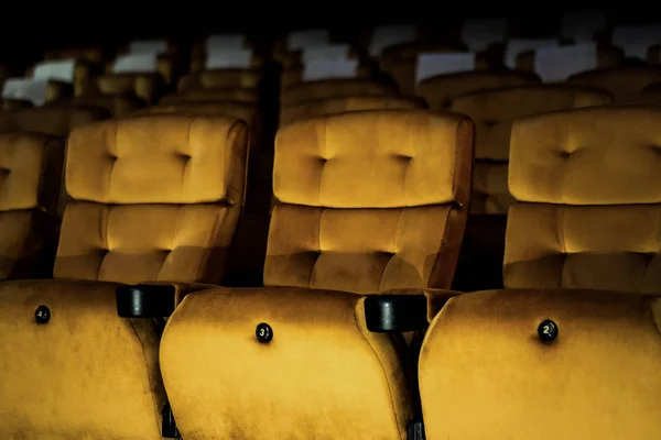 A row of yellow seat with popcorn on chair in the movie theater