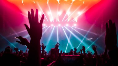 Mutlu insanlar gece kulübü DJ parti konserinde dans eder ve sahnede DJ 'den elektronik dans müziği dinlerler. Siluet dolu neşeli kalabalık 2020 yılbaşı partisini kutluyor. İnsanların yaşam tarzı DJ gece hayatı.