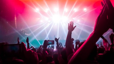 Mutlu insanlar gece kulübü DJ parti konserinde dans eder ve sahnede DJ 'den elektronik dans müziği dinlerler. Siluet dolu neşeli kalabalık 2020 yılbaşı partisini kutluyor. İnsanların yaşam tarzı DJ gece hayatı.