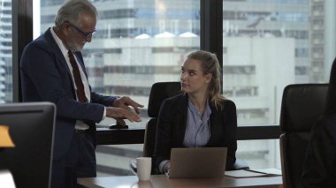 Üst düzey yönetici modern ofisteki genç kadın çalışana tavsiyelerde bulunuyor. Liderlik ve eğitim kavramı.
