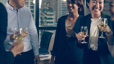 Başarılı iş adamları balo salonunda takım arkadaşlarıyla şarap ve şampanya içerek yeni ürünleri piyasaya sürme projesini kutluyorlar. Kurumsal iş ve insan ağ kurma kavramı.