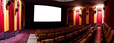 Sinematograftan yansıtılan beyaz ekranı gösteren sinema salonundaki koltukların önündeki sinema ekranı. Sinema klasik stil ile dekore edilmiştir. Lüks sinema izleme duygusu için..