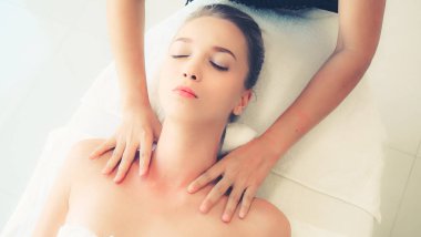 Profesyonel masaj terapisti tarafından masaj yaptıran rahat bir kadın. Sağlık, şifa ve rahatlama konsepti.