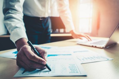 İş adamı muhasebeci ya da finans uzmanı şirket ofisindeki iş raporu grafiğini ve finans şemasını analiz eder. Finans ekonomisi, bankacılık sektörü ve borsa araştırmaları kavramı.