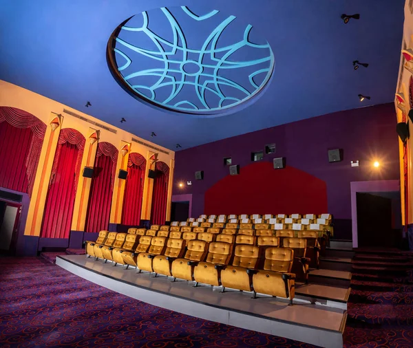 Large cinema theater interior with seat rows for audience to sit in movie theater premiere by cinematograph projector. The cinema theater is decorated in classical for luxury feel of movie watching.