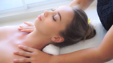 Profesyonel masaj terapisti tarafından masaj yaptıran rahat bir kadın. Sağlık, şifa ve rahatlama konsepti.