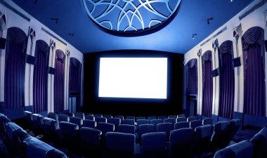 Sinematograftan yansıtılan beyaz ekranı gösteren sinema salonundaki koltukların önündeki sinema ekranı. Sinema klasik stil ile dekore edilmiştir. Lüks sinema izleme duygusu için..