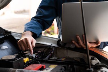 Oto tamirhanesinde araba tamiri ve bakım hizmeti veren profesyonel bir tamirci. Araba servisi iş konsepti.