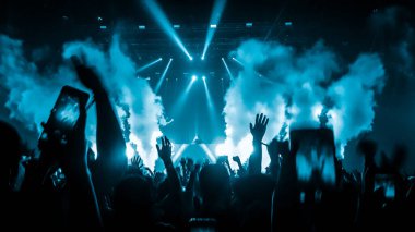 Mutlu insanlar gece kulübü DJ parti konserinde dans eder ve sahnede DJ 'den elektronik dans müziği dinlerler. Siluet dolu neşeli kalabalık 2020 yılbaşı partisini kutluyor. İnsanların yaşam tarzı DJ gece hayatı.