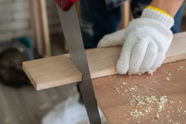 Marangoz atölyede ahşap işçiliği yapıyor. İnşaat malzemesi ya da ahşap mobilya üretiyor. Genç Asyalı marangoz zanaat için profesyonel araçlar kullanır. DIY üreticisi ve marangozluk konsepti.