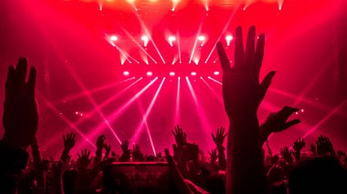 Mutlu insanlar gece kulübü DJ parti konserinde dans eder ve sahnede DJ 'den elektronik dans müziği dinlerler. Siluet dolu neşeli kalabalık 2020 yılbaşı partisini kutluyor. İnsanların yaşam tarzı DJ gece hayatı.