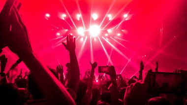 Mutlu insanlar gece kulübü DJ parti konserinde dans eder ve sahnede DJ 'den elektronik dans müziği dinlerler. Siluet dolu neşeli kalabalık 2020 yılbaşı partisini kutluyor. İnsanların yaşam tarzı DJ gece hayatı.