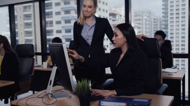 Genç lider modern ofisteki genç kadın çalışana tavsiyelerde bulunuyor. Liderlik ve eğitim kavramı.