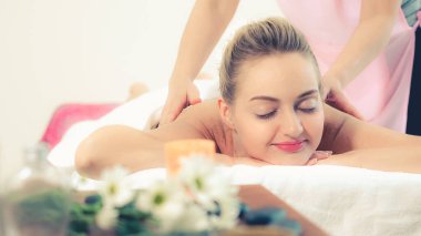 Rahat bir kadın profesyonel masaj terapistiyle lüks kaplıcalarda masaj yaptırıyor. Sağlık, şifa ve rahatlama konsepti.