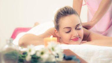 Rahat bir kadın profesyonel masaj terapistiyle lüks kaplıcalarda masaj yaptırıyor. Sağlık, şifa ve rahatlama konsepti.