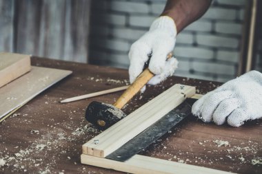 Marangoz atölyede ahşap işçiliği yapıyor. İnşaat malzemesi ya da ahşap mobilya üretiyor. Genç Asyalı marangoz zanaat için profesyonel araçlar kullanır. DIY üreticisi ve marangozluk konsepti.