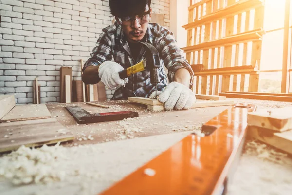 建設材料や木製の家具を生産するためにワークショップで木工に取り組んで大工 若いアジアの大工は作るための専門的な用具を使用する Diyメーカーと大工仕事のコンセプト — ストック写真