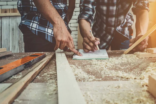 Marangoz atölyede ahşap işçiliği yapıyor. İnşaat malzemesi ya da ahşap mobilya üretiyor. Genç Asyalı marangoz zanaat için profesyonel araçlar kullanır. DIY üreticisi ve marangozluk konsepti.