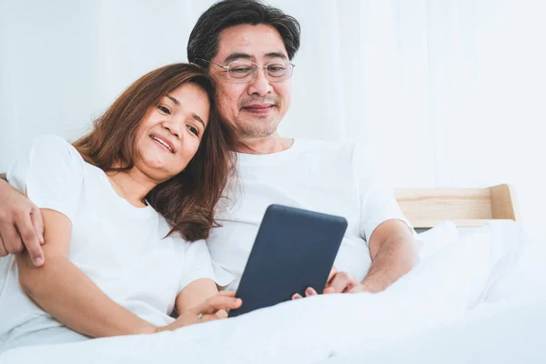 Happy Asian senior couple having good time at home. Old people retirement and healthy citizens elderly concept.