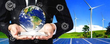 Alternatif enerji ile sürdürülebilirlik gelişimi kavramı. Çevre dostu rüzgar türbini çiftliği ve arka planda yeşil yenilenebilir enerji ile insan eliyle dünya ile ilgilenin..
