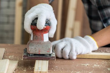Marangoz atölyede ahşap işçiliği yapıyor. İnşaat malzemesi ya da ahşap mobilya üretiyor. Genç Asyalı marangoz zanaat için profesyonel araçlar kullanır. DIY üreticisi ve marangozluk konsepti.
