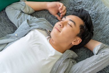 Mutlu Asyalı çift oturma odasının zemininde birlikte yatıyorlar. Aşk ilişkisi ve yaşam tarzı kavramı.