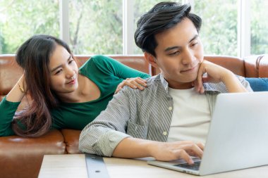 Genç çift evdeki internet sitesinden online alışveriş için kredi kartını kullanıyor. Kredi kartındaki numara sahte. Kredi kartında kişisel bilgi yok. Çevrimiçi iş alışveriş kavramı.