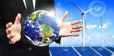 Alternatif enerji ile sürdürülebilirlik gelişimi kavramı. Çevre dostu rüzgar türbini çiftliği ve arka planda yeşil yenilenebilir enerji ile insan eliyle dünya ile ilgilenin..