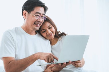 Mutlu Asyalı son sınıf çifti evde iyi vakit geçiriyor. Yaşlıların emekliliği ve sağlıklı vatandaşların ihtiyarlık kavramı.