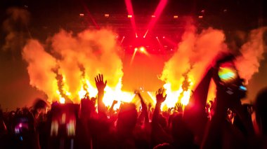 Mutlu insanlar gece kulübü DJ parti konserinde dans eder ve sahnede DJ 'den elektronik dans müziği dinlerler. Siluet dolu neşeli kalabalık 2020 yılbaşı partisini kutluyor. İnsanların yaşam tarzı DJ gece hayatı.