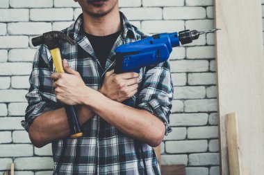 Marangoz atölyede ahşap işçiliği yapıyor. İnşaat malzemesi ya da ahşap mobilya üretiyor. Genç Asyalı marangoz zanaat için profesyonel araçlar kullanır. DIY üreticisi ve marangozluk konsepti.