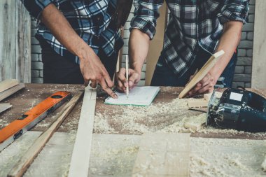 Marangoz atölyede ahşap işçiliği yapıyor. İnşaat malzemesi ya da ahşap mobilya üretiyor. Genç Asyalı marangoz zanaat için profesyonel araçlar kullanır. DIY üreticisi ve marangozluk konsepti.