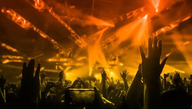 Mutlu insanlar gece kulübü DJ parti konserinde dans eder ve sahnede DJ 'den elektronik dans müziği dinlerler. Siluet dolu neşeli kalabalık 2020 yılbaşı partisini kutluyor. İnsanların yaşam tarzı DJ gece hayatı.