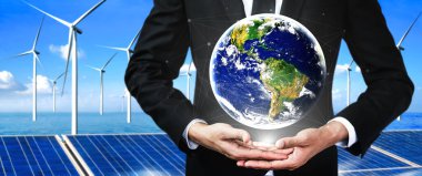 Alternatif enerji ile sürdürülebilirlik gelişimi kavramı. Çevre dostu rüzgar türbini çiftliği ve arka planda yeşil yenilenebilir enerji ile insan eliyle dünya ile ilgilenin..