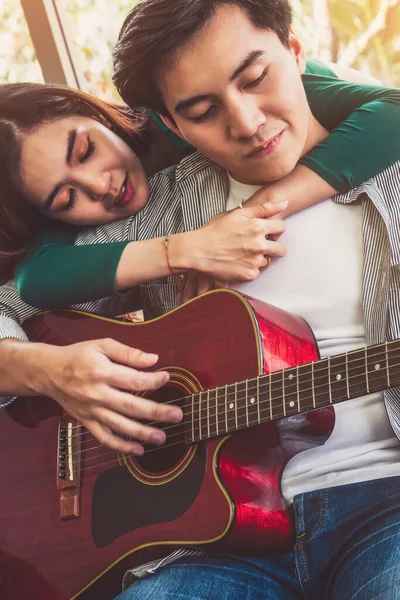 年轻的亚洲夫妇在家里客厅里一起弹奏吉他和唱歌 音乐与生活方式的概念 — 图库照片