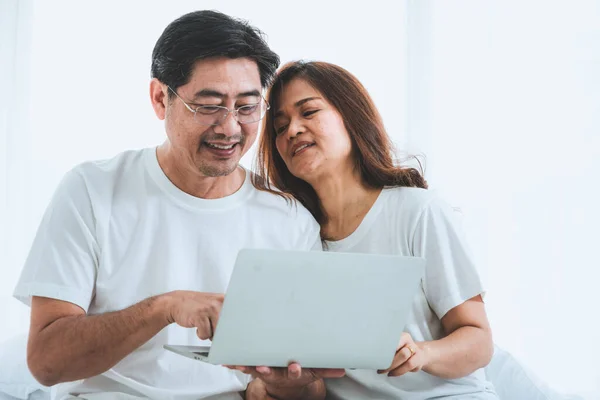 Happy Asian senior couple having good time at home. Old people retirement and healthy citizens elderly concept.